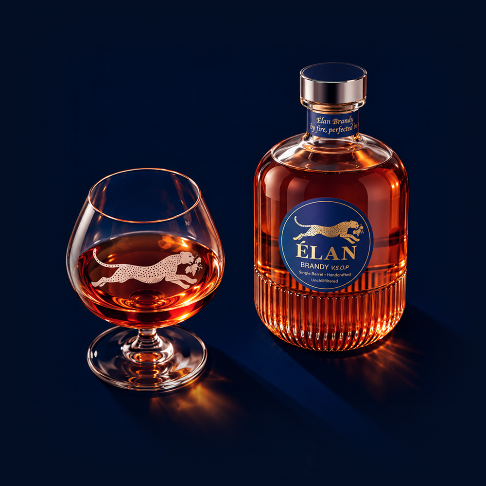 Eine Flasche Elan-Brandy neben einem Schnapsglas, beide mit einem goldenen Geparden-Logo versehen und mit bernsteinfarbener Flüssigkeit gefüllt.