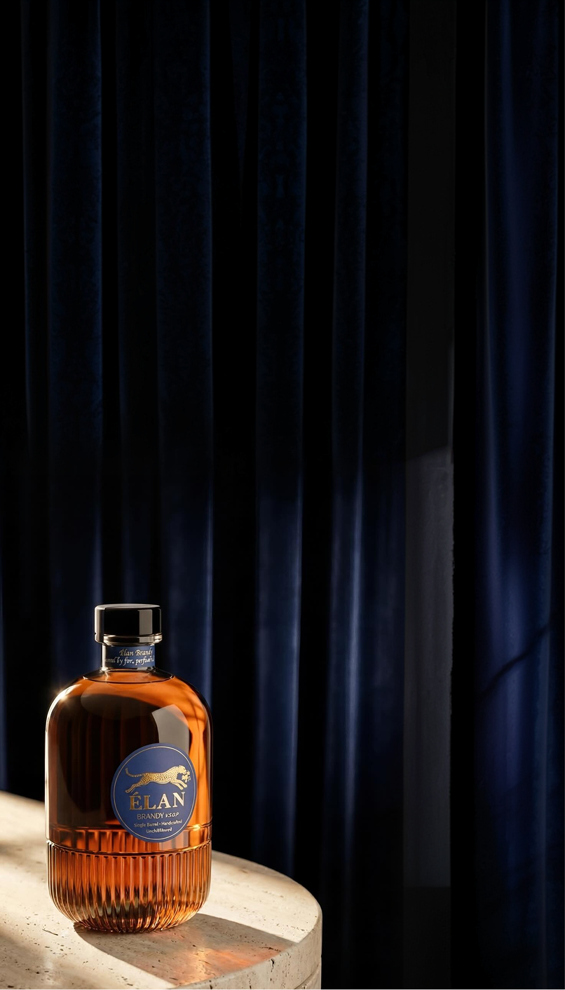Eine Flasche Élan Brandy VSOP auf einer Steinoberfläche vor dunkelblauen Vorhängen.